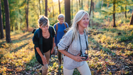 Drie vrouwen die door het bos wandelen.