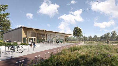 Vooraangezicht van het gebouw met fietsenstalling en terras.