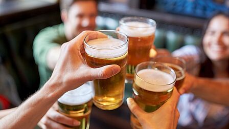 Mensen die proosten met een glas bier