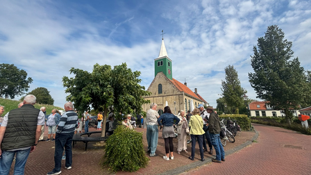 Mensen buiten bij het kerkje in Andijk
