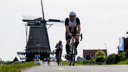 Wielrenner in Westfries landschap met molen